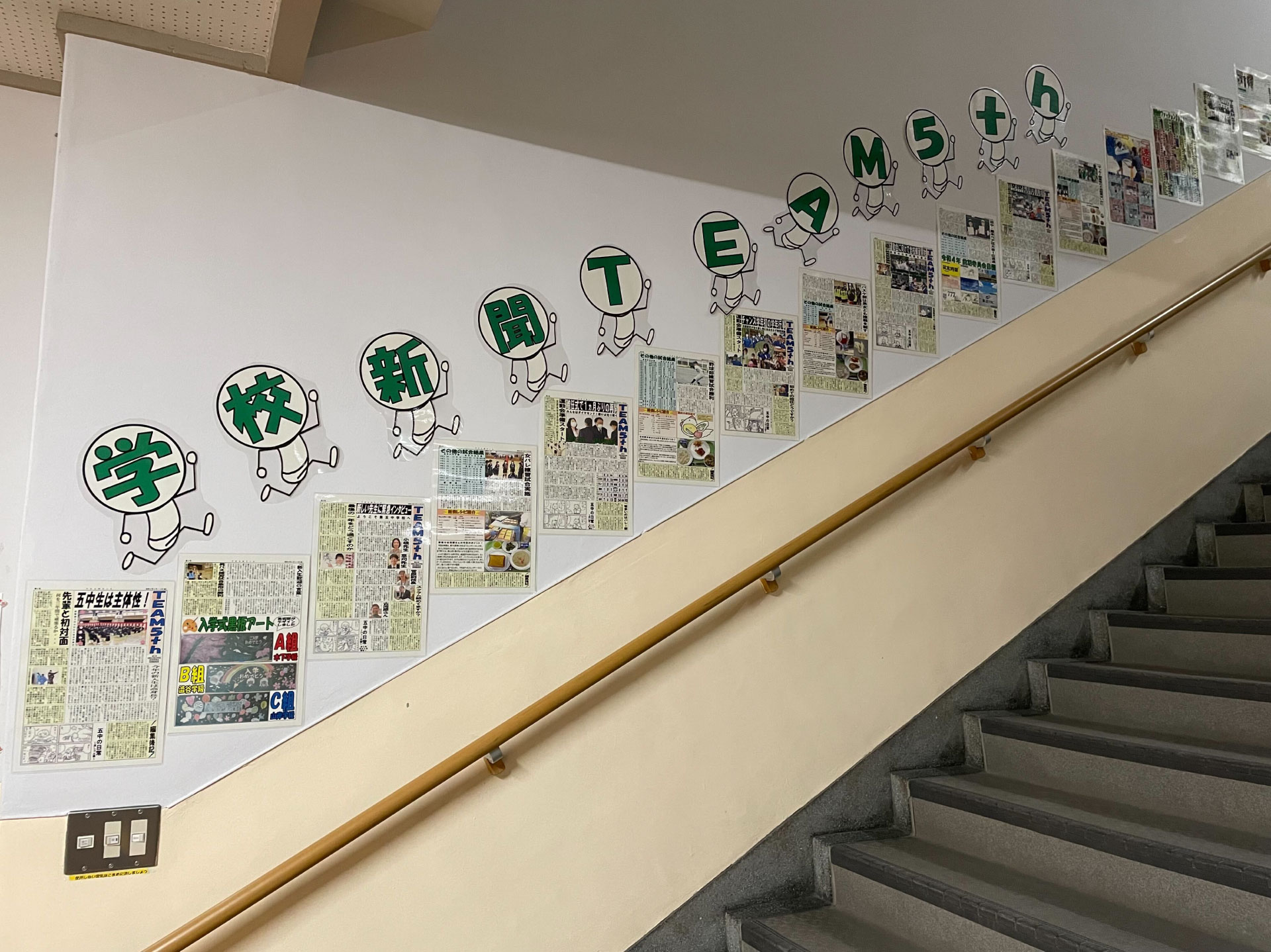 階段に学校新聞が貼り出されている様子