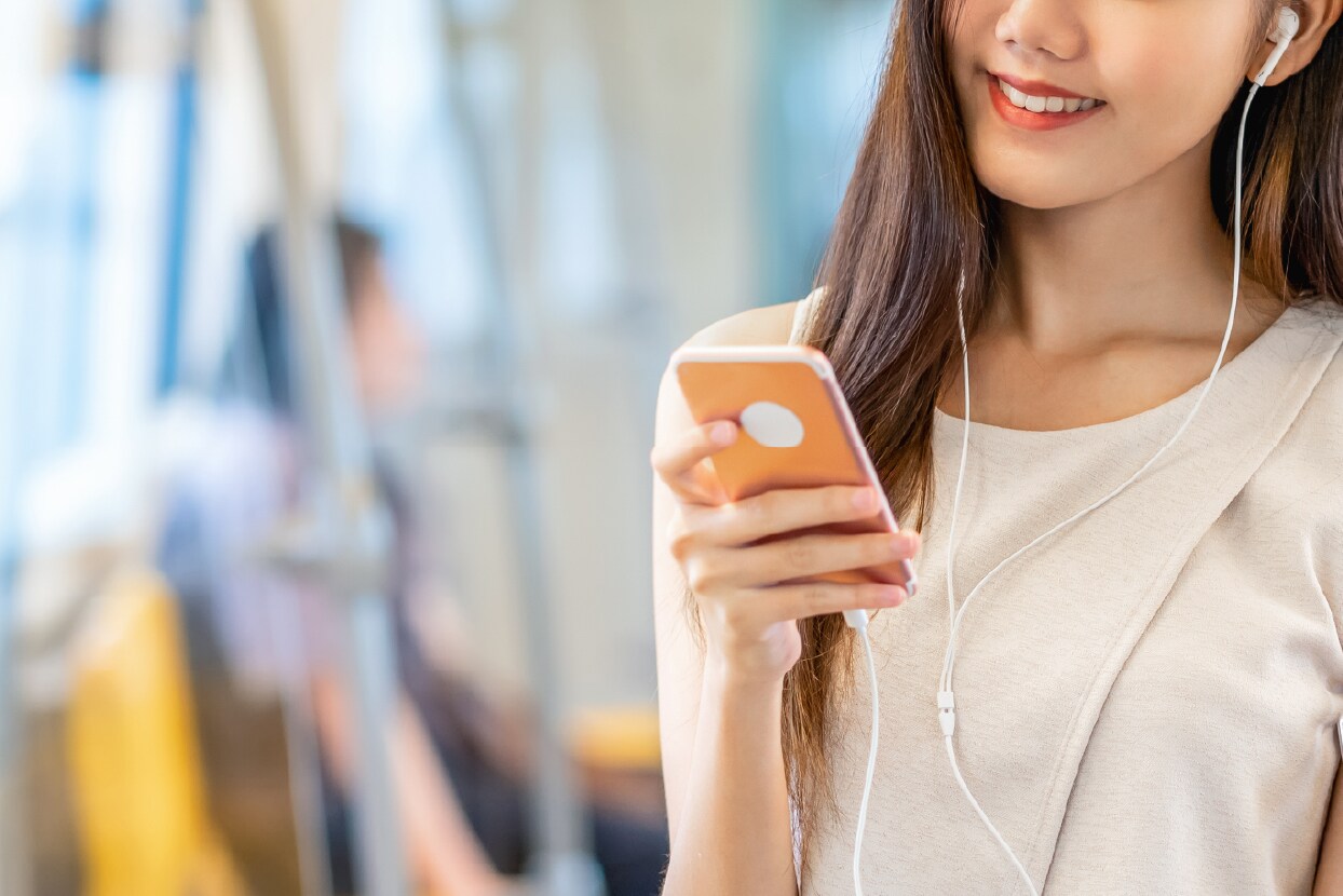 電車でスマートフォンを使って英語んおトレーニングしているイメージ写真