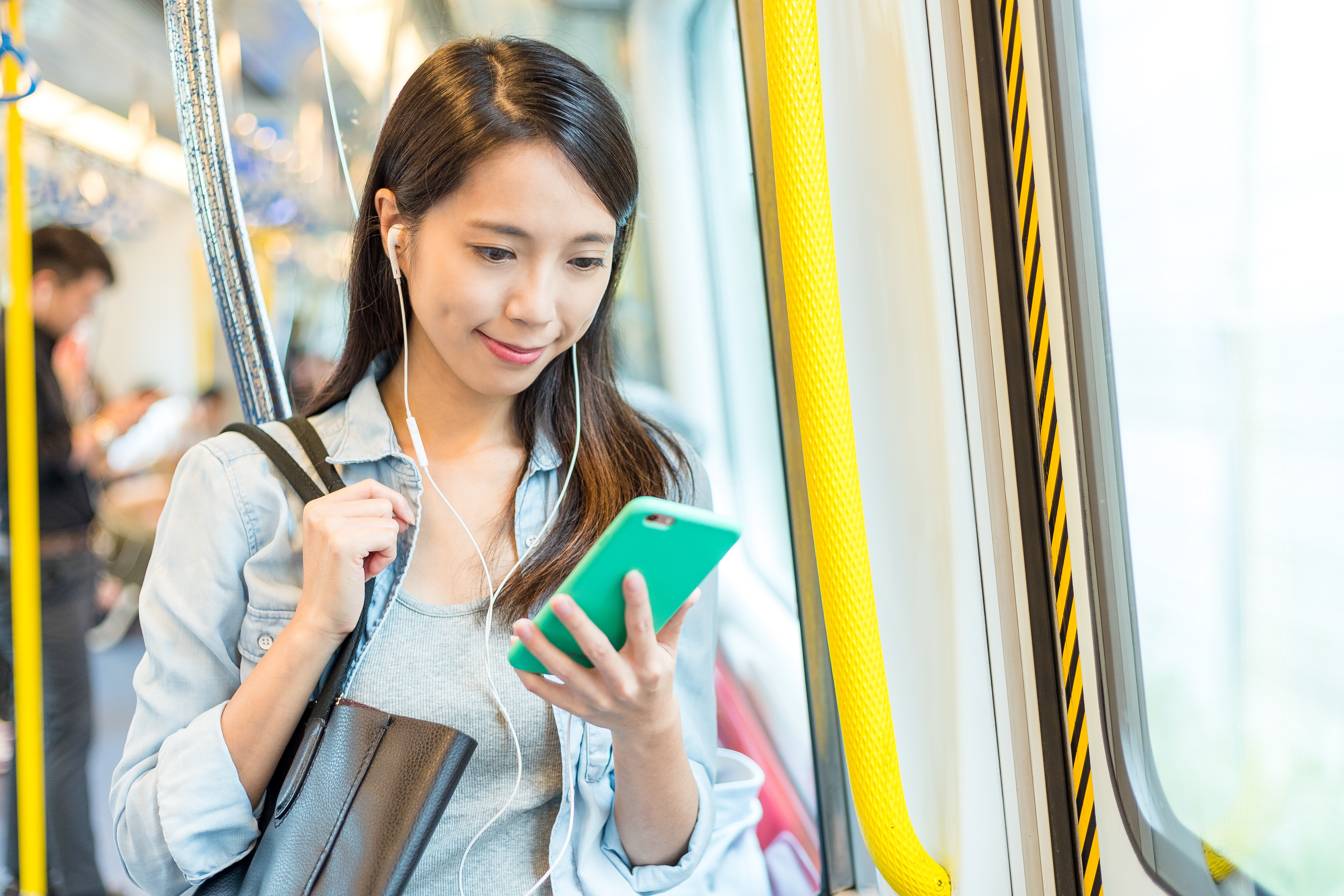 電車の中でスマホを利用してスーパーエルマーで学習している女性のイメージ